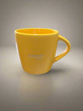 Yellow mug with 'Rayovac' branding on a reflective surface